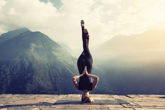 Young Woman Doing Complex Yoga Exercise Headstand with Namaste Asana_ unframed gallery
